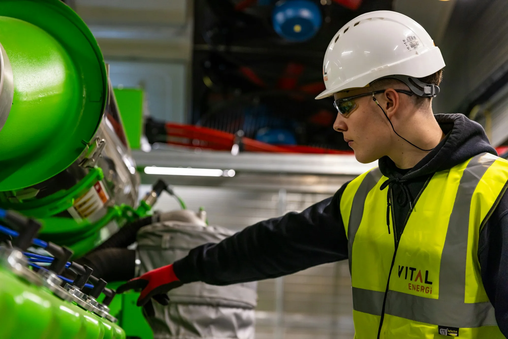 An engineer in protective equipment inspecting industrial machinery
