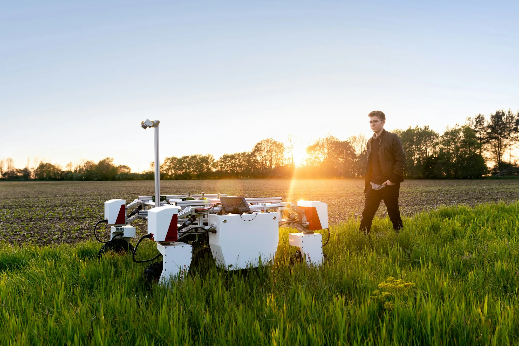 An engineer testing an agricultural robot in a field