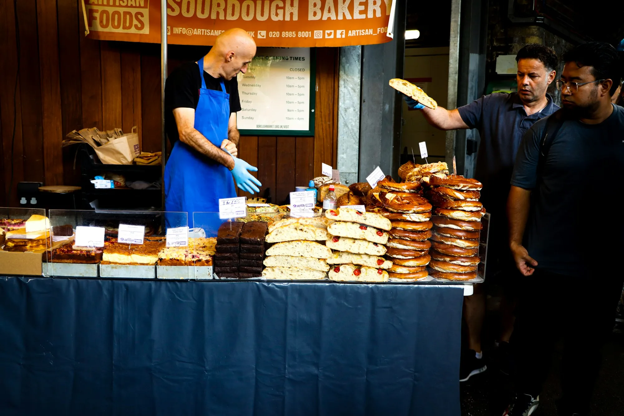 A baker serving pastries at a London food market